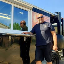 Rodney Dean, owner and pitmaster of Bone of My Bone BBQ, standing next to his smoker